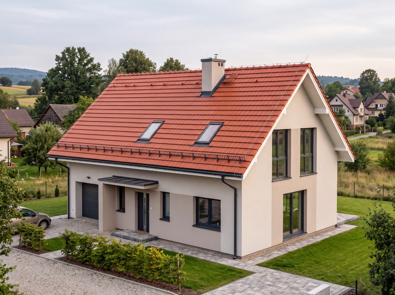 Dach kryty czerwoną dachówką ceramiczną z oknami połaciowymi i płotkami przeciwśniegowymi, dom jednorodzinny w Zielonkach
